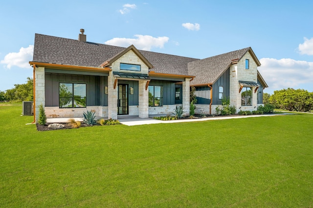 view of front of home with central AC unit and a front yard