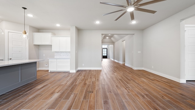 unfurnished living room featuring ceiling fan and light wood-type flooring