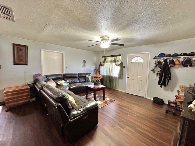 living room with ceiling fan, wood-type flooring, and a textured ceiling