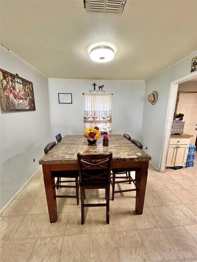 tiled dining area featuring a textured ceiling