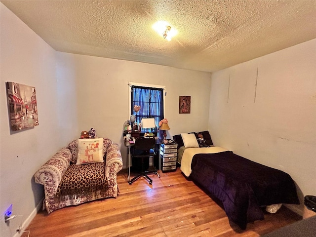 bedroom featuring light hardwood / wood-style floors and a textured ceiling