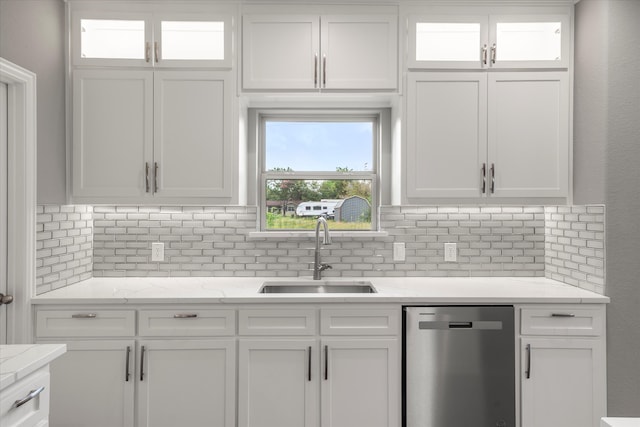 kitchen with white cabinetry, light stone countertops, sink, and stainless steel dishwasher