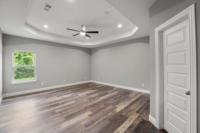 unfurnished room with ceiling fan, hardwood / wood-style flooring, and a tray ceiling