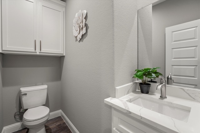 bathroom featuring wood-type flooring, toilet, and vanity