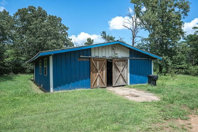 view of outbuilding featuring a yard