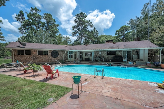 view of swimming pool featuring a yard and a patio