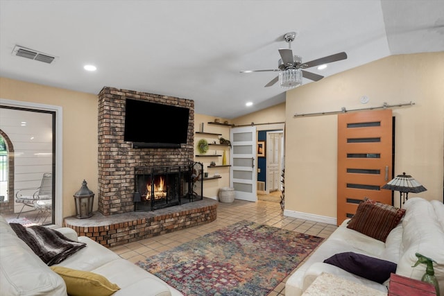 tiled living room with ceiling fan, a fireplace, lofted ceiling, and a barn door