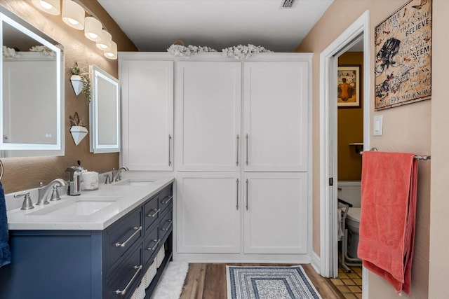 bathroom featuring vanity, hardwood / wood-style floors, and toilet