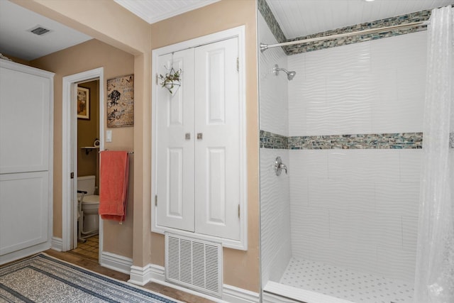 bathroom with toilet and tiled shower