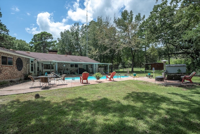 view of swimming pool with a storage shed, a patio area, and a lawn