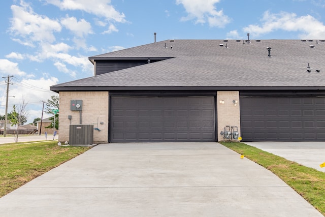 view of front of house featuring a garage and central AC