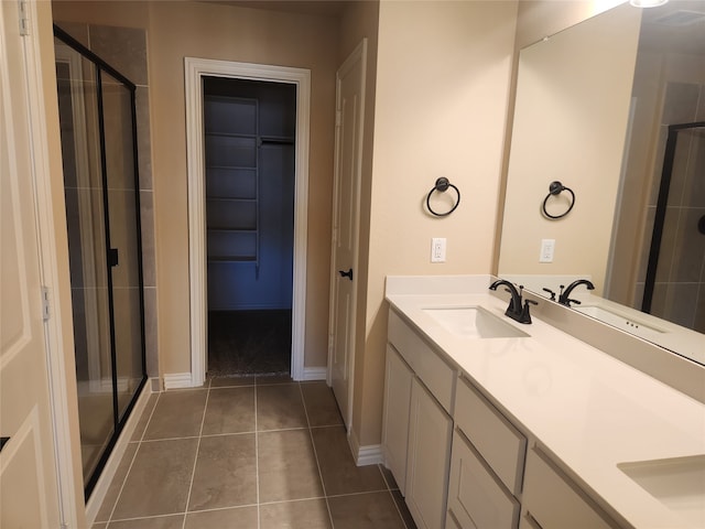 bathroom featuring an enclosed shower, tile patterned floors, and double sink vanity