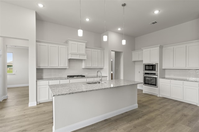 kitchen featuring white cabinetry, appliances with stainless steel finishes, sink, and light wood-type flooring