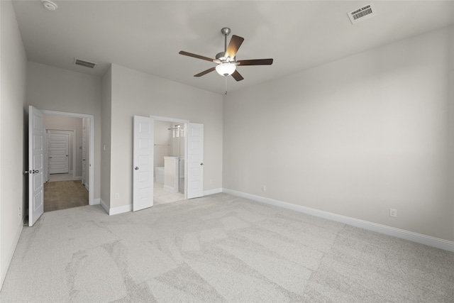 unfurnished bedroom featuring light carpet, ensuite bathroom, and ceiling fan