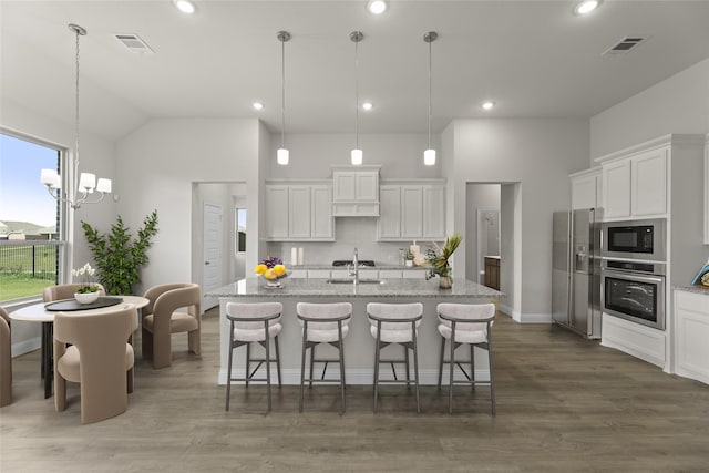 kitchen featuring appliances with stainless steel finishes, white cabinets, and pendant lighting