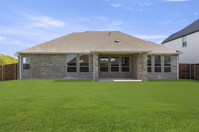 back of house with a patio and a lawn