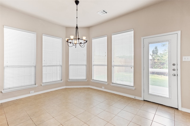 unfurnished dining area with an inviting chandelier and light tile patterned floors