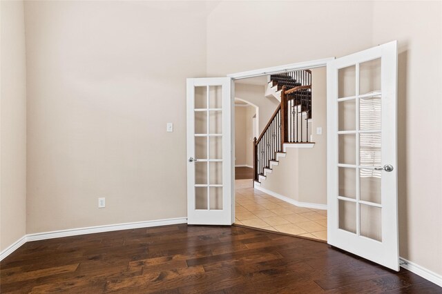 spare room featuring wood-type flooring and french doors