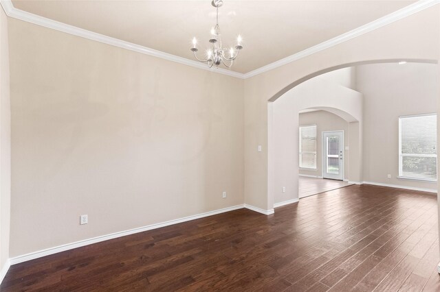 spare room featuring ornamental molding, a notable chandelier, and dark hardwood / wood-style floors