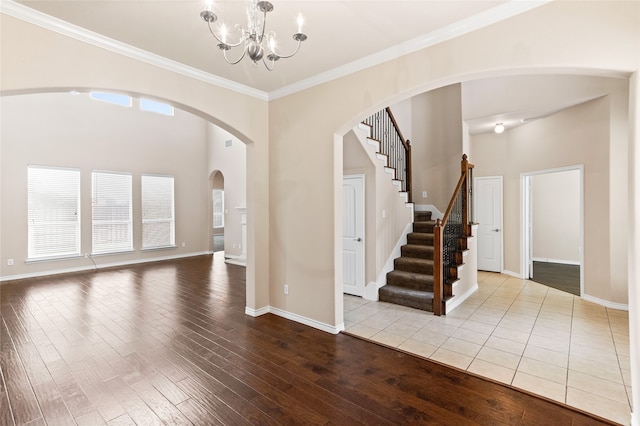 interior space featuring light wood-type flooring, crown molding, and an inviting chandelier