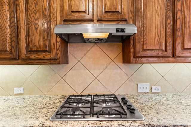 kitchen with stainless steel gas cooktop, light stone countertops, and tile patterned floors