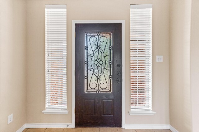 entrance foyer featuring plenty of natural light and light tile patterned flooring