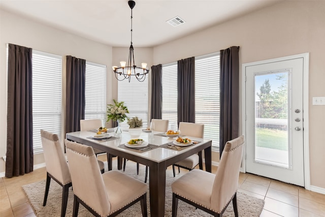 tiled dining room featuring an inviting chandelier