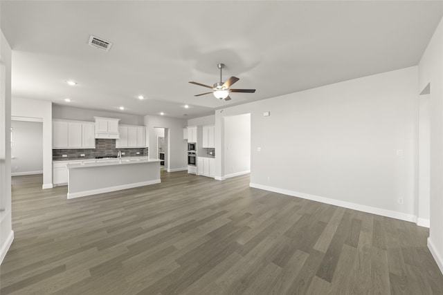 unfurnished living room featuring dark hardwood / wood-style floors and ceiling fan