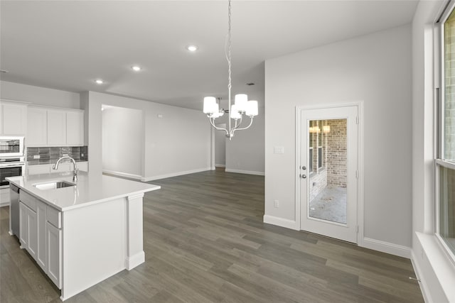 kitchen featuring a center island with sink, sink, appliances with stainless steel finishes, and white cabinetry