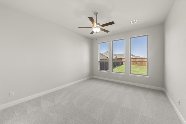 spare room with light colored carpet and ceiling fan