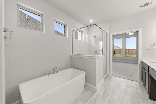 bathroom with vanity, shower with separate bathtub, ceiling fan, and a wealth of natural light