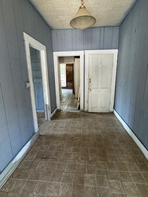 hallway featuring wood walls