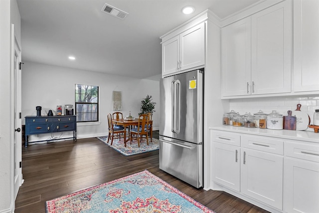 kitchen featuring white cabinetry, high end refrigerator, backsplash, and dark hardwood / wood-style flooring