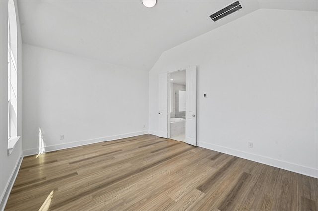 unfurnished room featuring vaulted ceiling and hardwood / wood-style flooring