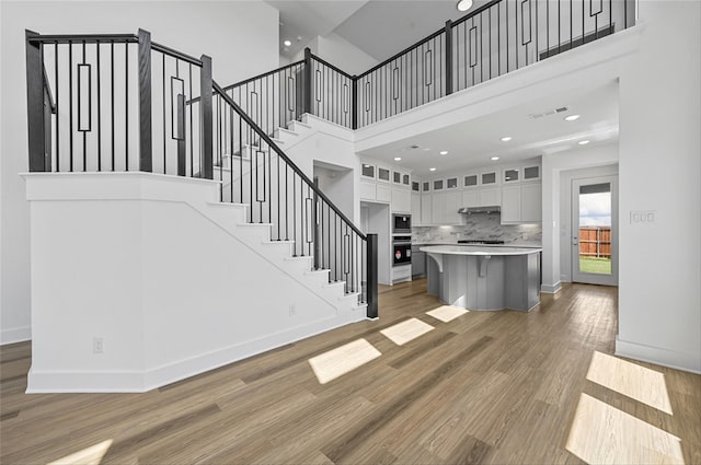 stairs featuring a high ceiling and hardwood / wood-style floors