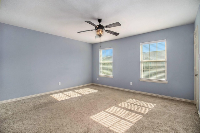 carpeted spare room featuring ceiling fan, a textured ceiling, and baseboards