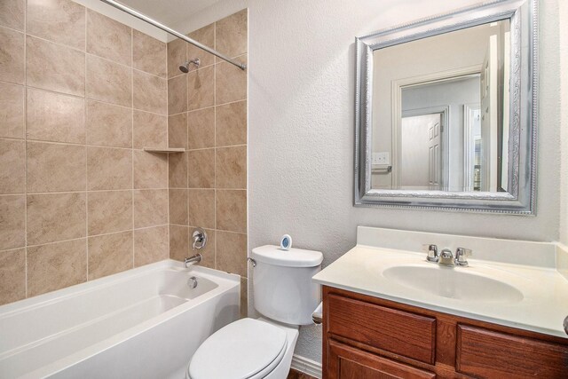 full bathroom with tiled shower / bath, vanity, and toilet