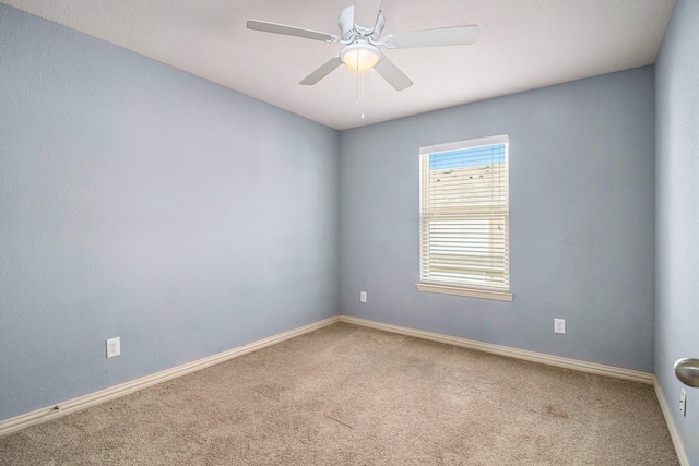 spare room featuring carpet, baseboards, and a ceiling fan