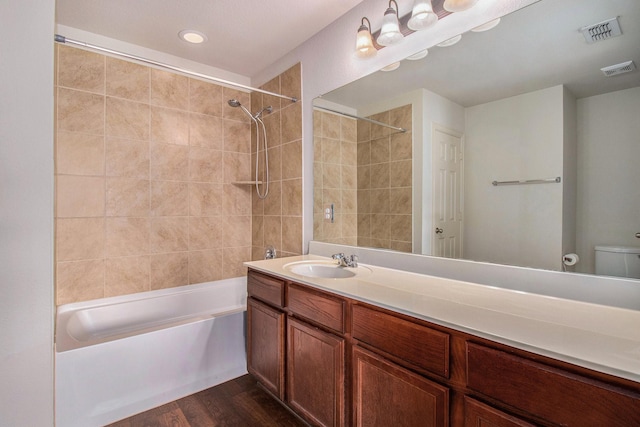 full bath featuring toilet, wood finished floors, bathtub / shower combination, and visible vents