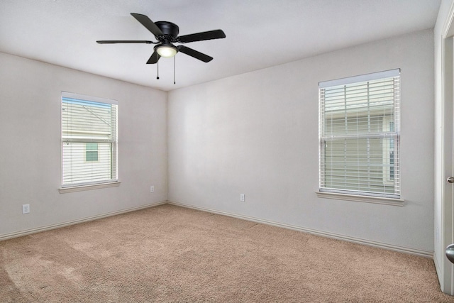 empty room with carpet flooring, a ceiling fan, and baseboards