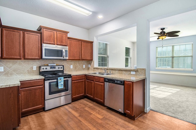 kitchen featuring ceiling fan, sink, appliances with stainless steel finishes, and dark wood-type flooring