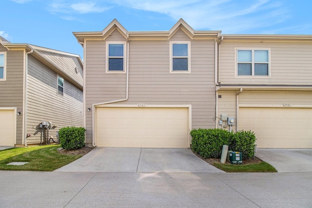 multi unit property with concrete driveway and an attached garage