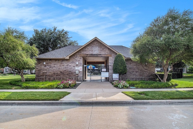 exterior space featuring a lawn and a gate