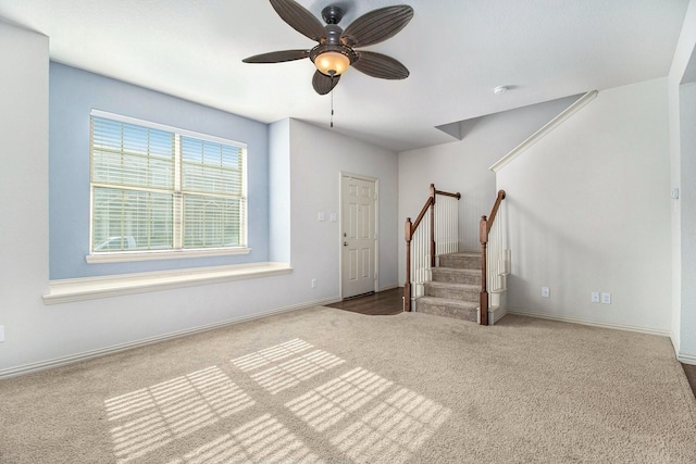 interior space featuring stairs, carpet floors, a ceiling fan, and baseboards