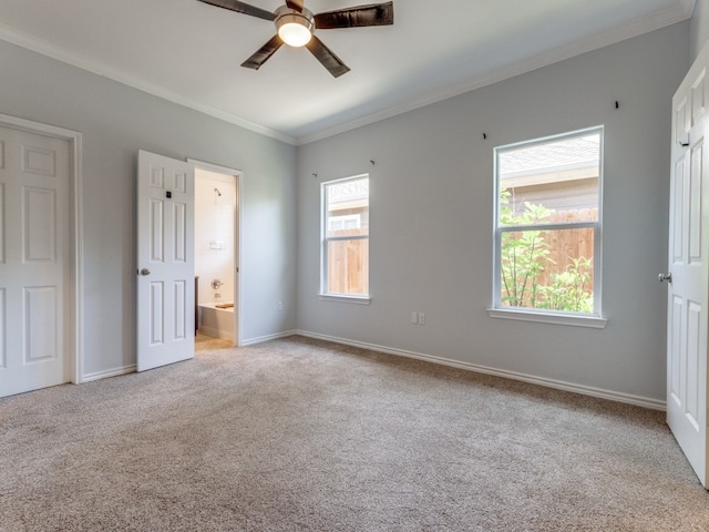 unfurnished bedroom with ceiling fan, crown molding, light colored carpet, and ensuite bath