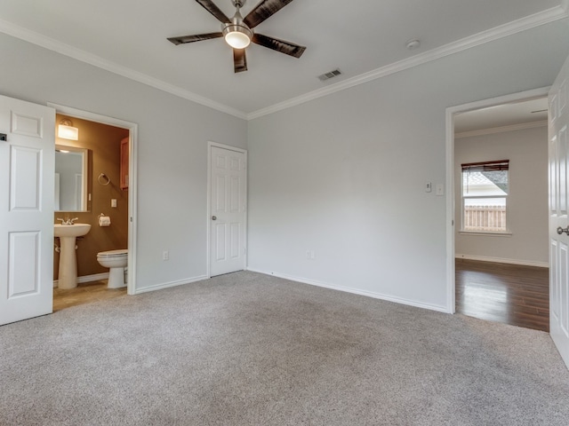 unfurnished bedroom with light colored carpet, connected bathroom, crown molding, and ceiling fan