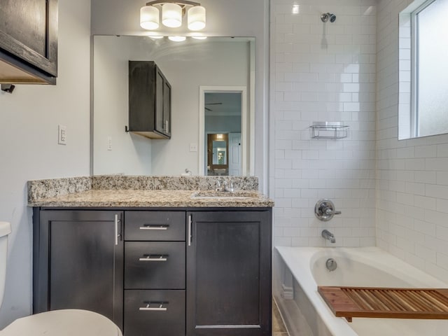 full bathroom with vanity, tiled shower / bath combo, and toilet