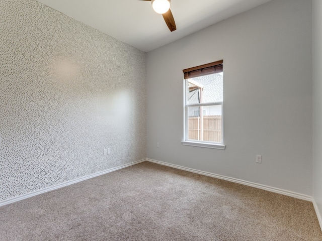 carpeted spare room featuring ceiling fan