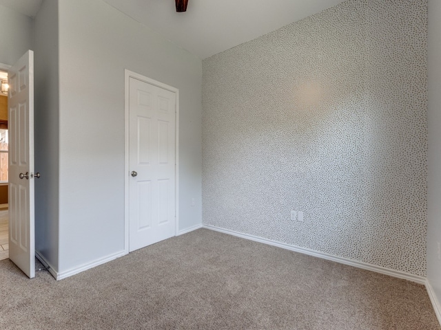 unfurnished bedroom with ceiling fan and light colored carpet