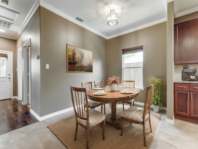 dining room with ornamental molding and light tile patterned floors